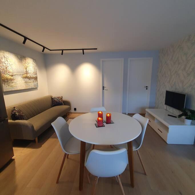 a living room with a white table and chairs at Ramfjord Apartment in Tromsø