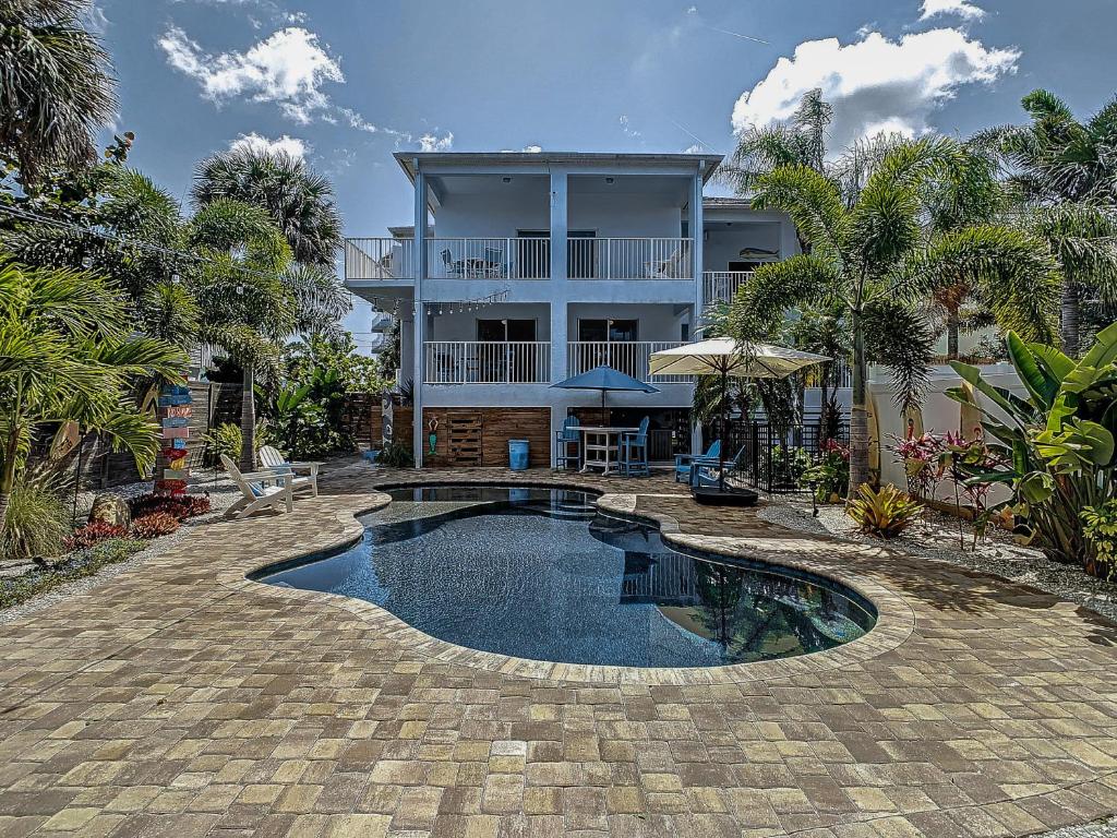 una casa con piscina frente a una casa en Salt Life Pool Home ~ Ocean Views ~ Walk to Flagler Avenue ~ 604S, en New Smyrna Beach