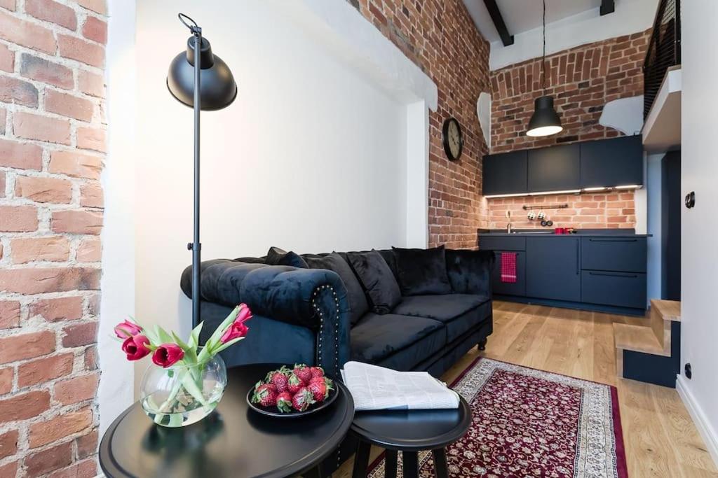 un salon avec un canapé et un mur de briques dans l'établissement Loft Black and Red, à Tallinn