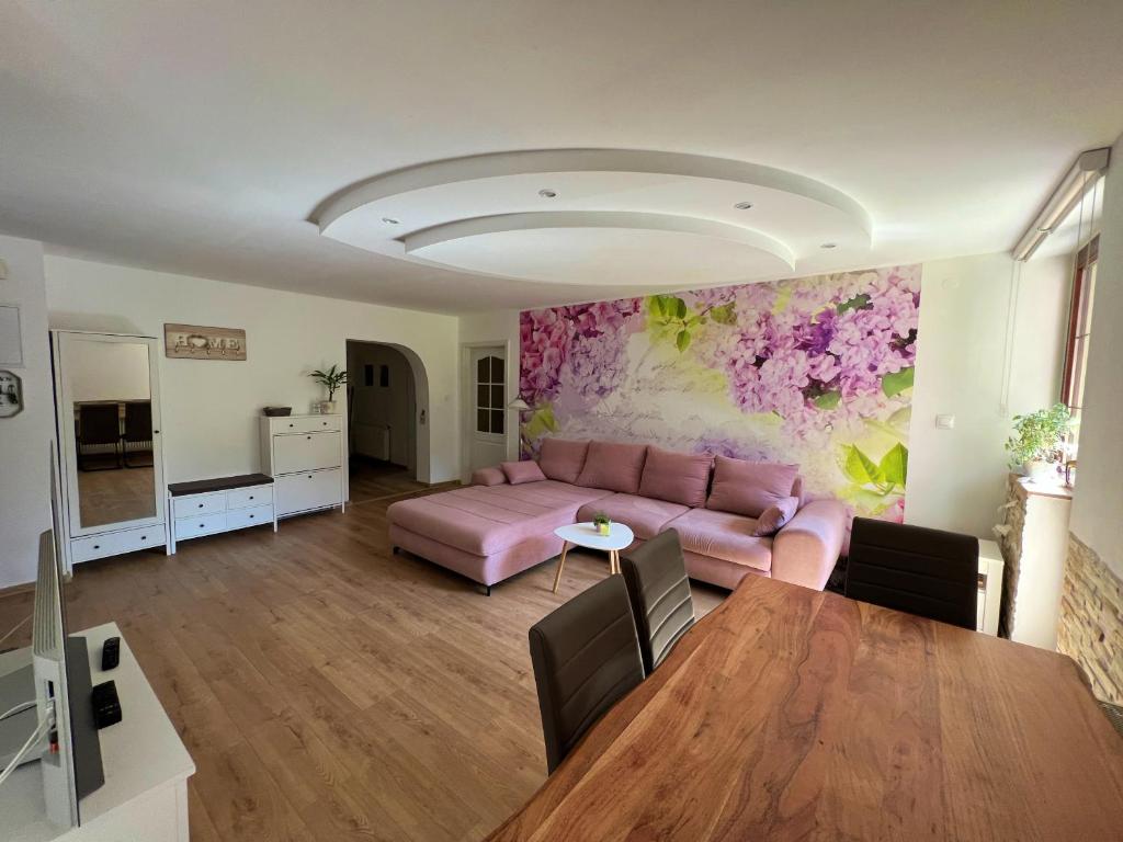 a living room with a pink couch and a table at Apartmán Stará Sásová in Banská Bystrica