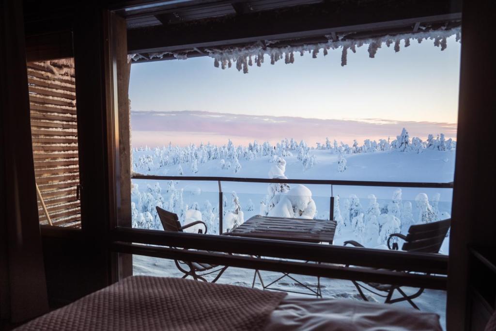 una camera con finestra affacciata su una scena invernale di Ruka Peak - Boutique Hotel & Restaurant a Ruka