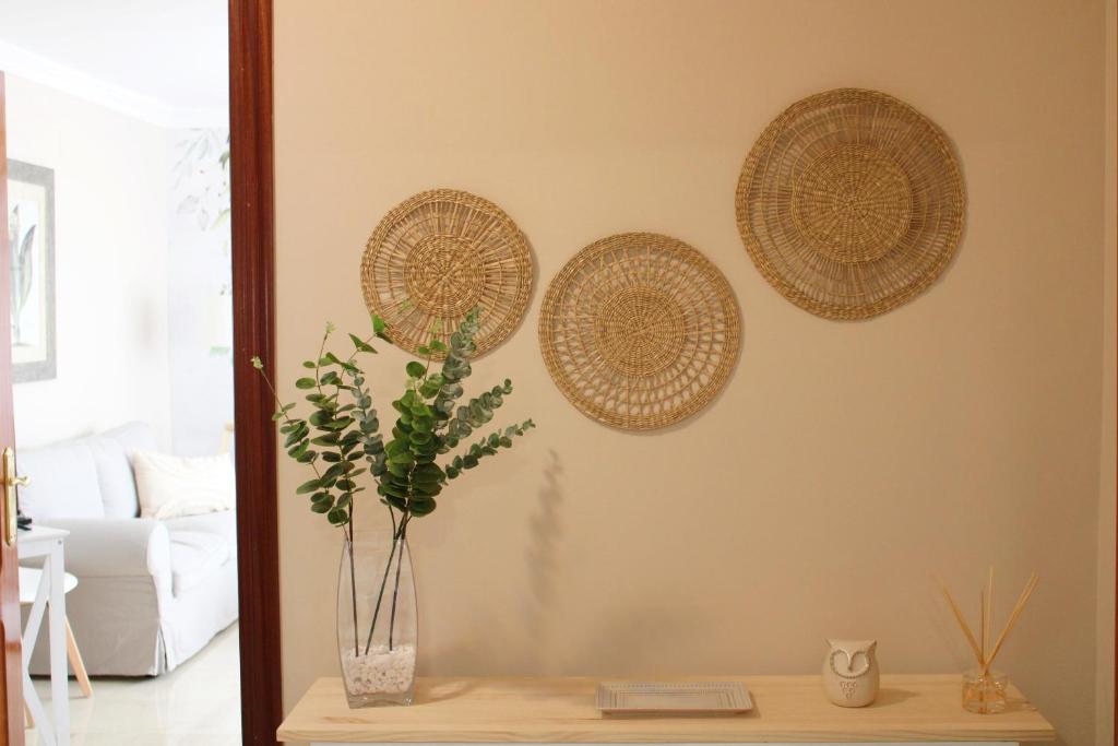 Sala de estar con mesa y 3 cestas en la pared en Córdoba Azahar, en Córdoba