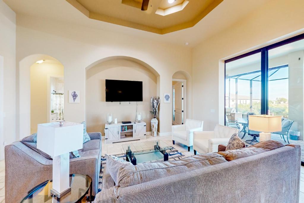 ein Wohnzimmer mit zwei Sofas und einem Fernseher in der Unterkunft Twilight Palms in Cape Coral