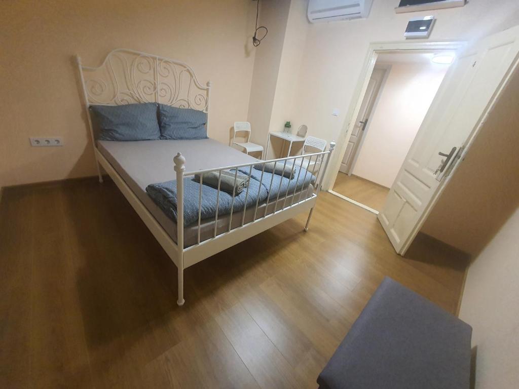 Schlafzimmer mit einem weißen Bett und Holzboden in der Unterkunft HANCHO - KAPANA CENTER PLOVDIV in Plowdiw