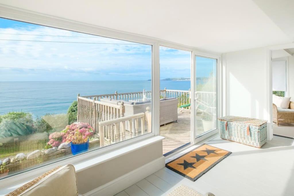 a room with a large window with a view of the ocean at Mesmerising sea views - Penrose - above the beach Cornwall. in Downderry