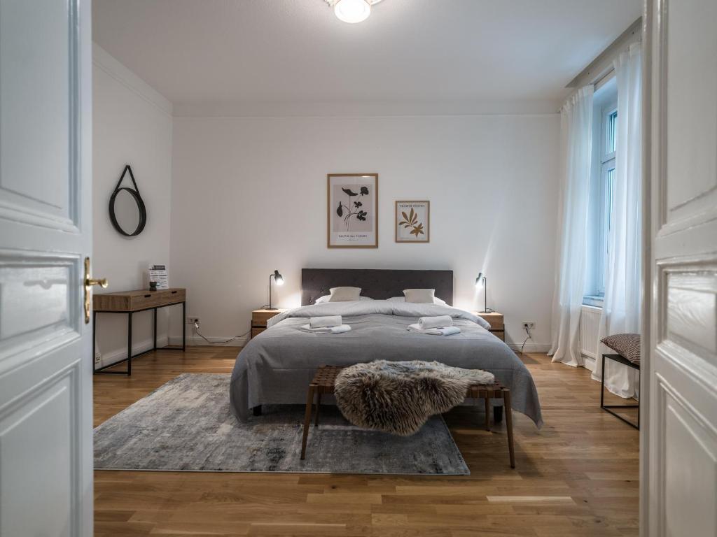 Habitación blanca con cama y alfombra en Hochwertige Altbauwohnung im modernen Stil in Wiesbaden - Küche - Terrasse - WLAN - Zentral en Wiesbaden