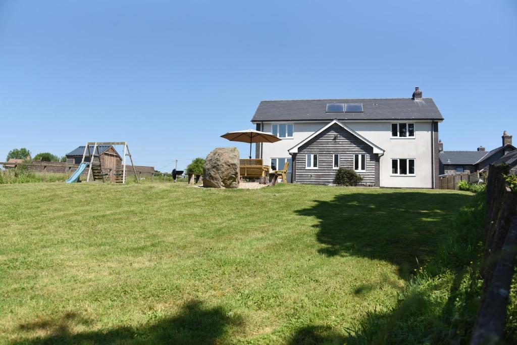 een huis op een grasveld met een schuur bij Maen Llwyd in Llanyre