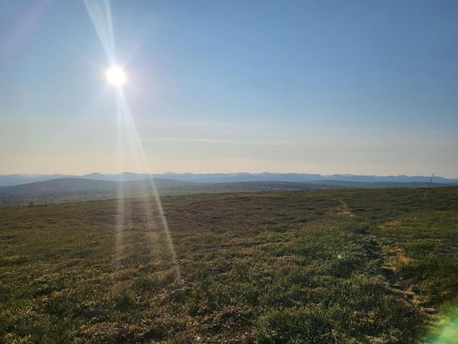 an open field with the sun in the sky at Cozy mountain house in Jämtland in Vallrun