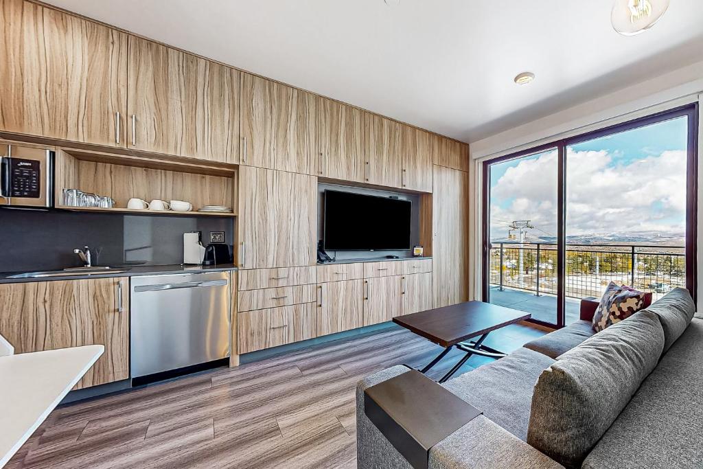 een keuken en een woonkamer met een bank en een televisie bij Canyons Resort Village #129 in Park City