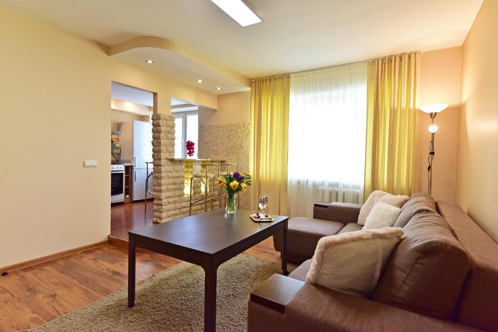 a living room with a couch and a table at Holiday Apartments with loggia in Druskininkai in Druskininkai