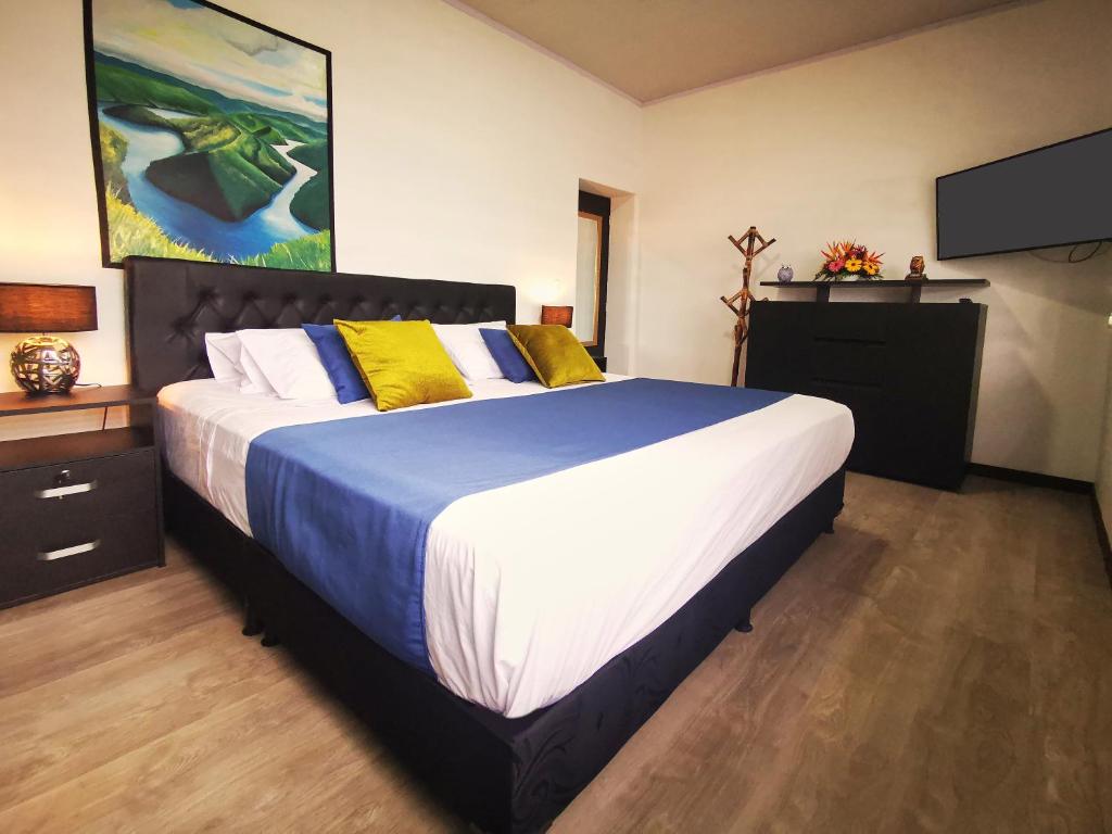 a bedroom with a large bed and a television at El solar casa hotel in Manizales