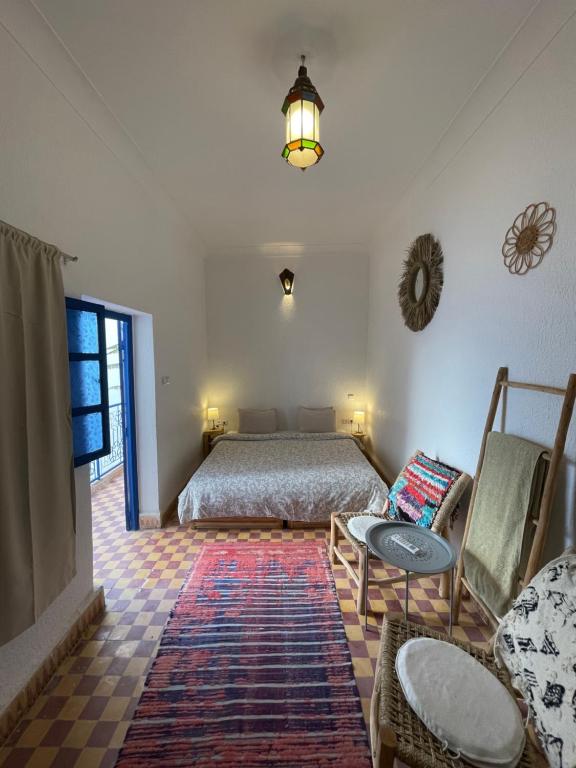 una camera con letto, tavolo e sedie di Riad Yu Yu a Marrakech