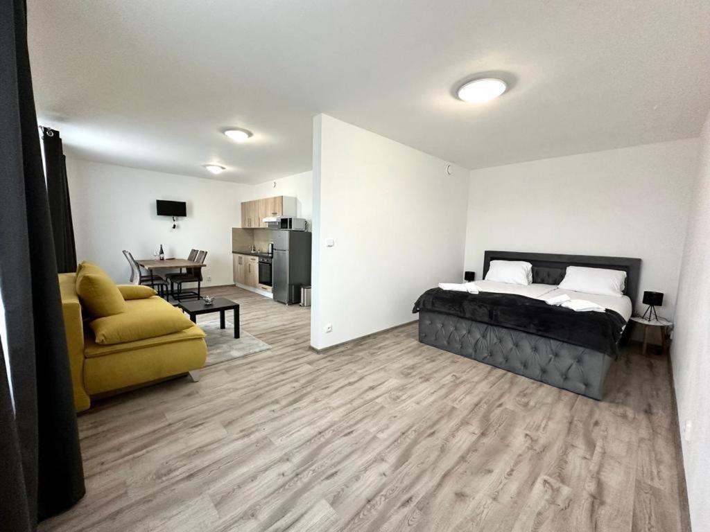 a bedroom with a bed and a couch and a kitchen at Sky apartments 508 in Pilsen