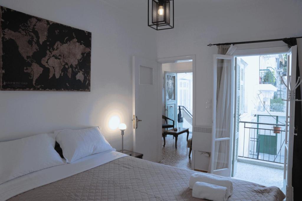 ein weißes Schlafzimmer mit einem Bett und einem Balkon in der Unterkunft Sigma Acropolis Upstairs in Athen