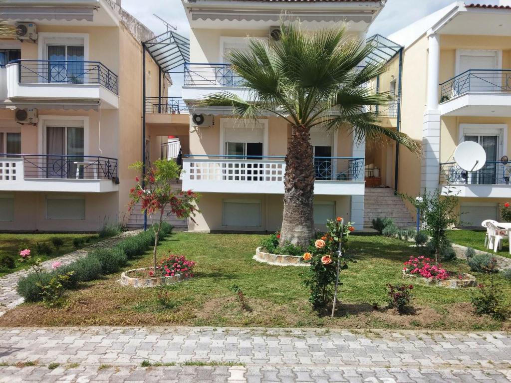 a palm tree in front of a building at Esperides Villas in Fourka