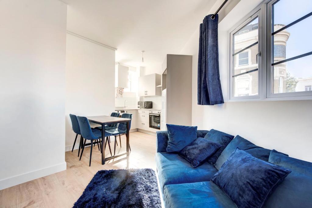a living room with a blue couch and a table at 2 Bedroom Apartment in Brixton with Wi-Fi in London