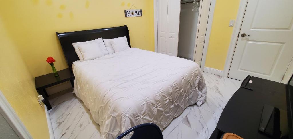 ein Schlafzimmer mit einem Bett mit einer weißen Bettdecke in der Unterkunft tom house in Tampa