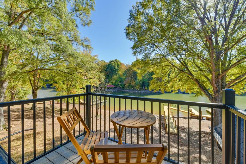 een tafel en stoelen op een balkon met uitzicht op een rivier bij The Retreat at Lake Norman with Shared Dock and Slip in Mooresville