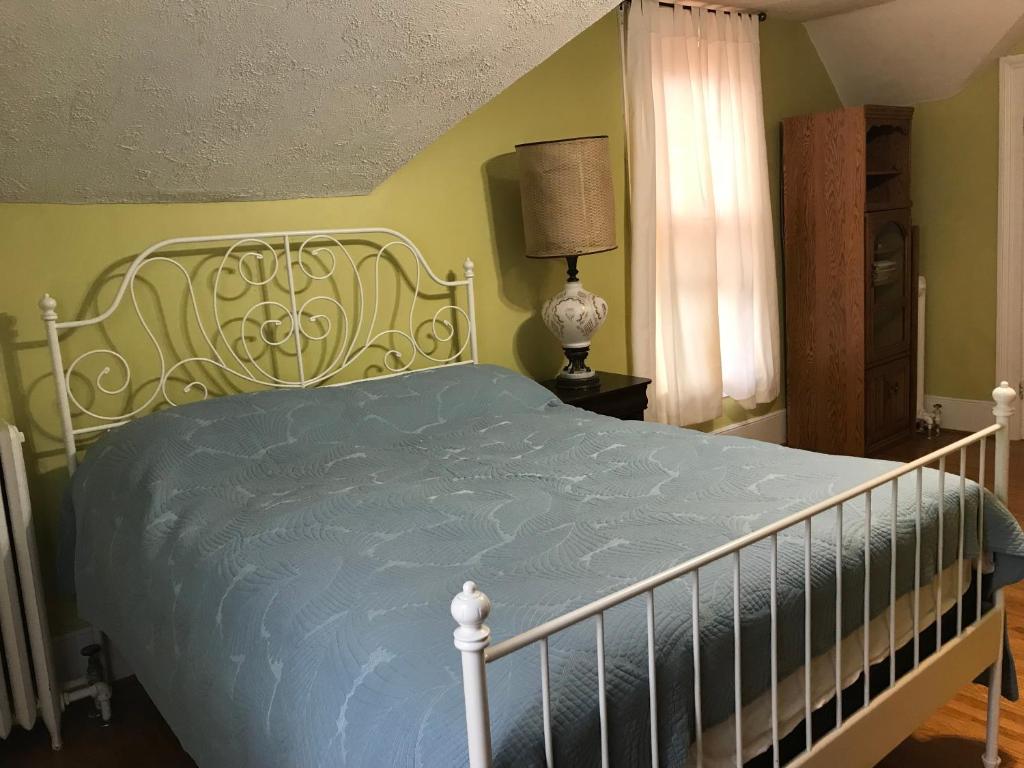 a bedroom with a bed with a blue comforter at ROOM A IN THE WHITE HOUSE in Niagara Falls