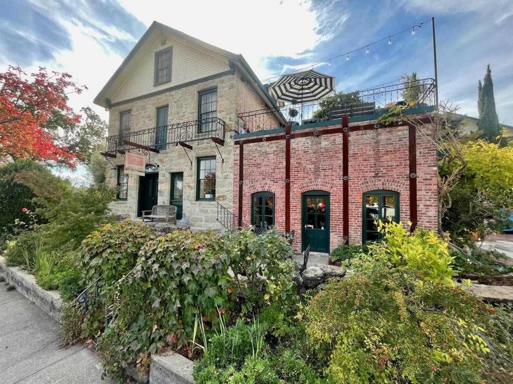 un vecchio edificio di mattoni con un cartello sopra di Maison Fleurie, A Four Sisters Inn a Yountville