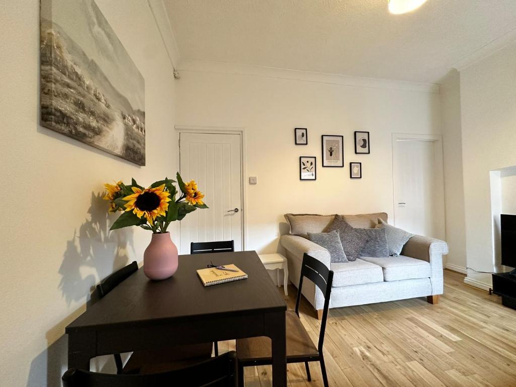 een woonkamer met een tafel en een bank bij 4 bed 3 bedroom home near Middlesbrough centre in Middlesbrough