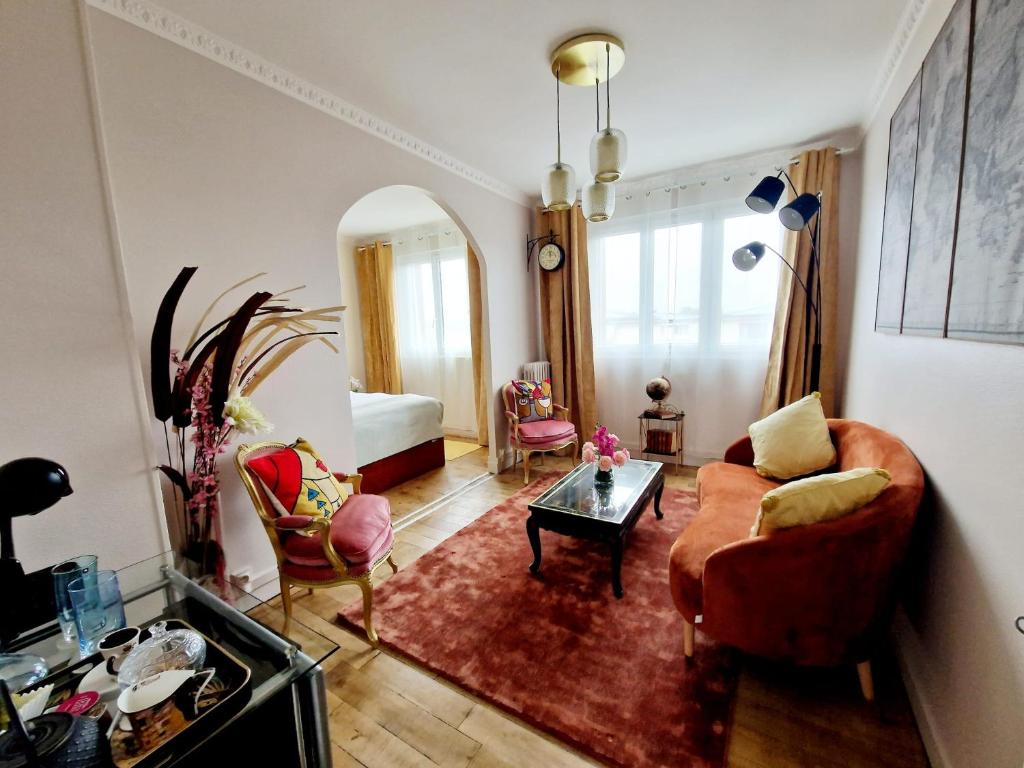 un soggiorno con divano e tavolo di location chambre chez l'habitant a Épinay-sur-Seine