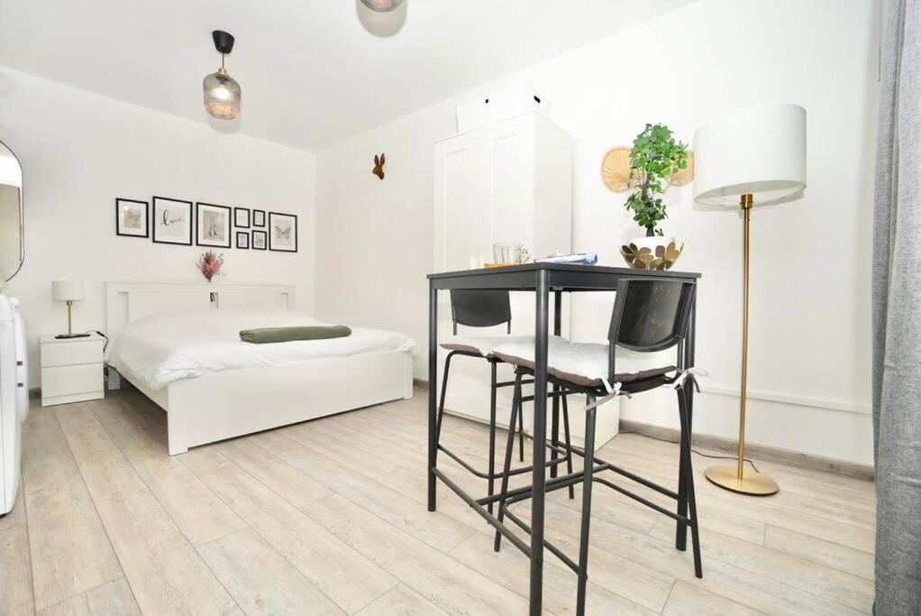Un dormitorio con una cama, una mesa y una silla. en Le temple du calme, en Metz