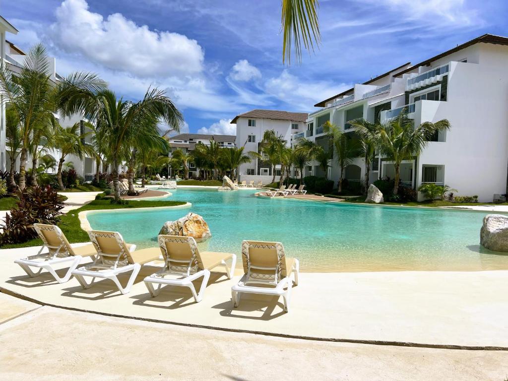 una piscina con tumbonas y un complejo en Komfortowy Apartament z 4 Basenami i Pięknym Ogrodem, Estrella Dominicus-Bayahibe, en Bayahibe