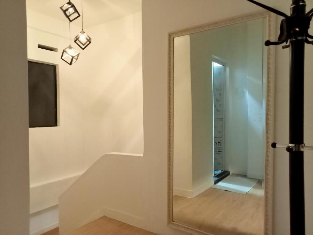 a mirror in a white room with a hallway at Malay Homestay TEREZ138 Banda Hilir in Melaka
