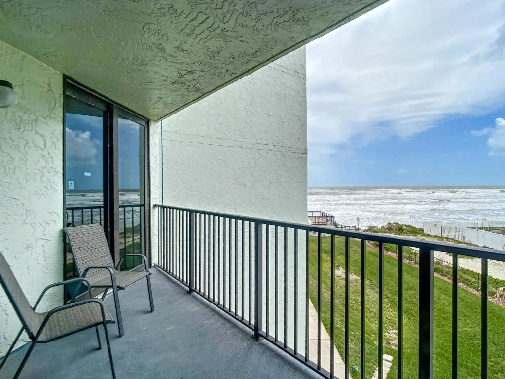 balcón con 2 sillas y vistas al océano en Ocean View with a beachfront pool at Ocean Trillium ~ 301, en New Smyrna Beach