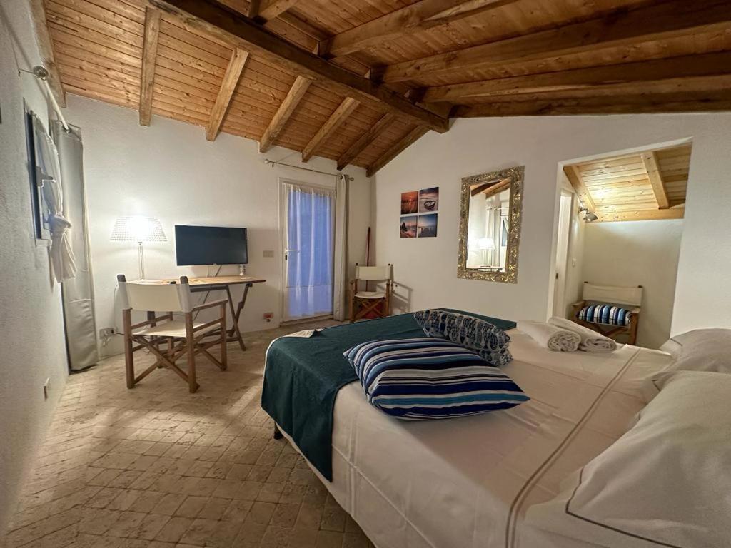 a bedroom with a large bed and a desk at Residenza ammiraglio Filippo in Varigotti