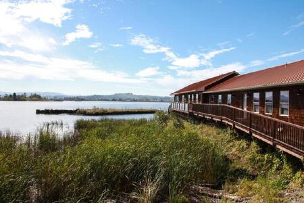 a train on a track next to a body of water at Charming Hideaway Overlooking The Astoria Waters in Astoria, Oregon