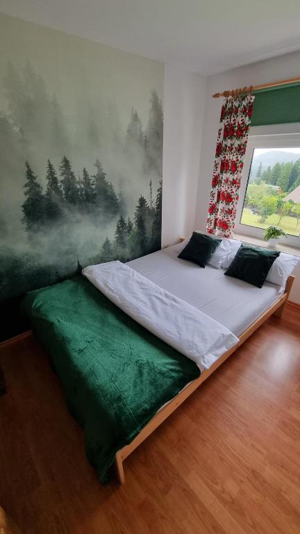 Góralski domek na szczycie في زواردون: سرير في غرفة نوم مع لوحة على الحائط
