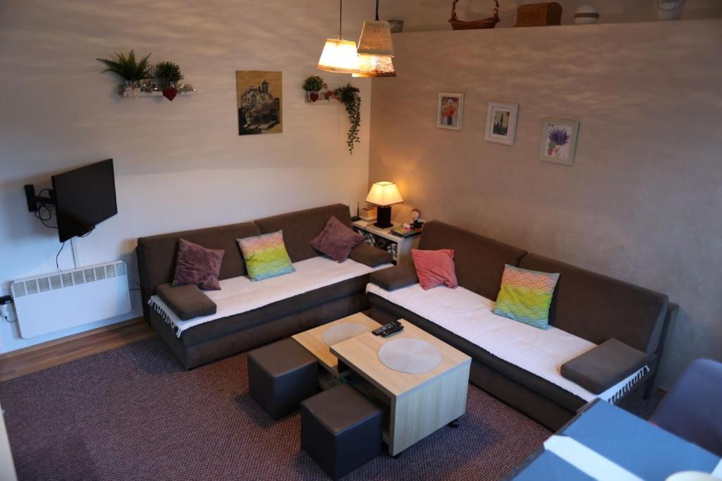 a living room with two couches and a table at Apartman 1 Zlaja Vlašić in Vlasic