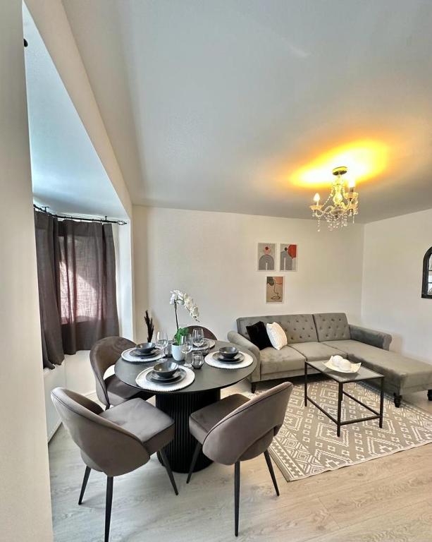 een woonkamer met een tafel en stoelen en een bank bij Modern and spacious flat in Longbridge