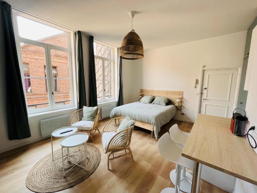 sypialnia z łóżkiem, stołem i krzesłami w obiekcie Appartement Chaleureux en Hyper Centre à Lille w Lille