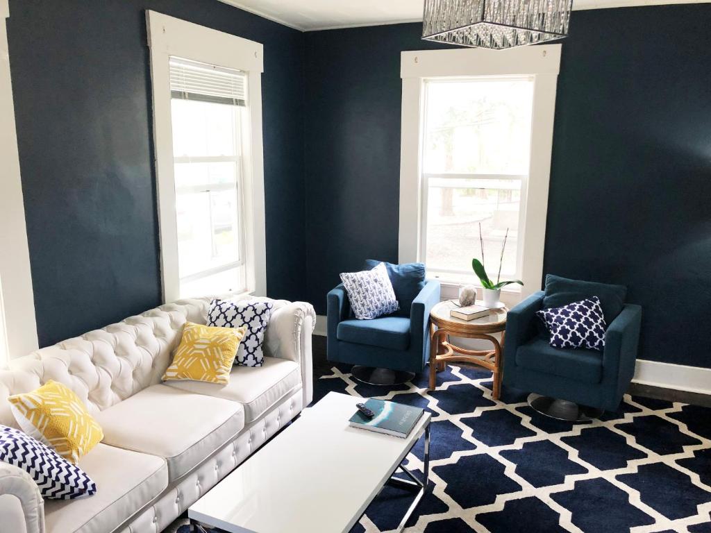 a living room with a white couch and two blue chairs at The Madison House in Minneapolis