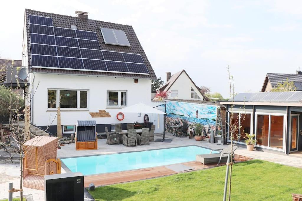 a house with a swimming pool with solar panels on it at Exklusive Dorfpension mit Pool und Sauna in Lage