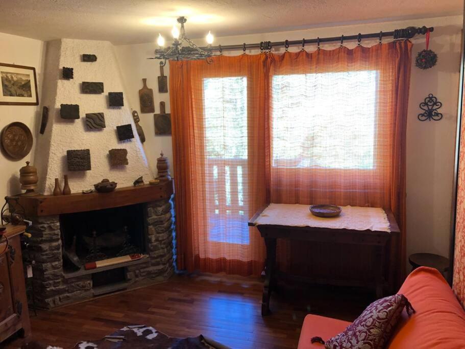un salon avec une cheminée et une fenêtre dans l'établissement Un nido accogliente con vista, à Verrand