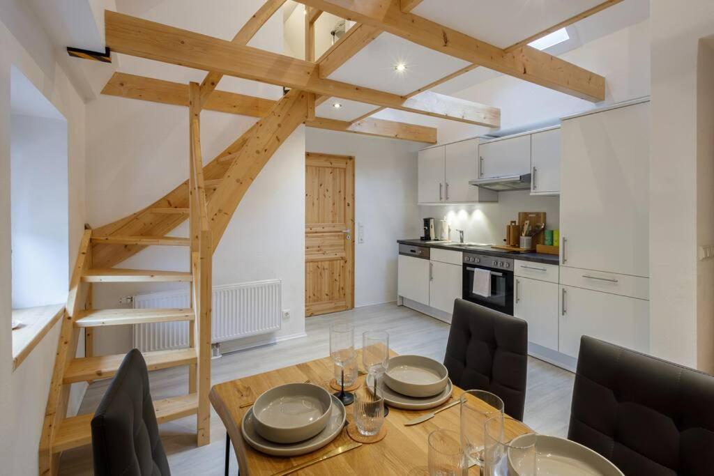 cocina y comedor con mesa de madera y sillas en Exklusives Tiny House in Elbnähe en Buxtehude
