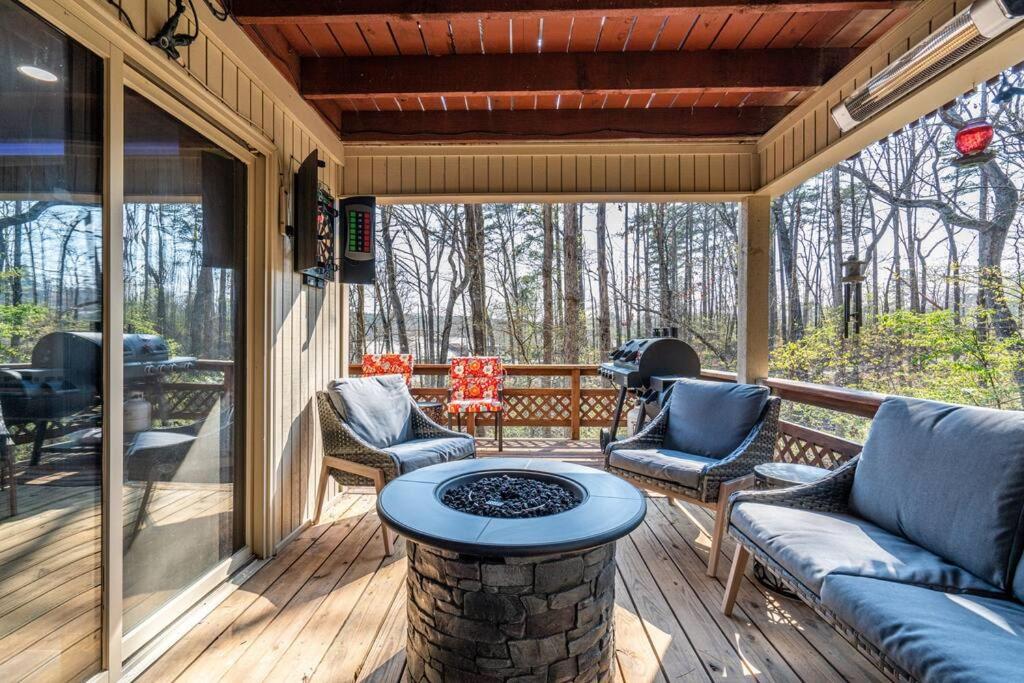 un porche cubierto con mesa y sillas en My Happy Place-Games, Lakeside, & Scenery Views, en Hot Springs