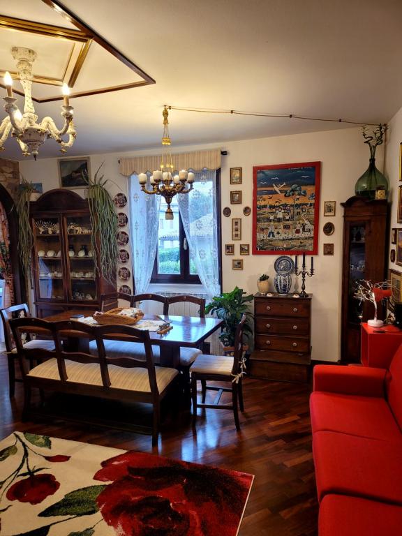 a living room with a table and a red couch at La Torretta a 10 minuti dal lago di Garda in Castiglione delle Stiviere