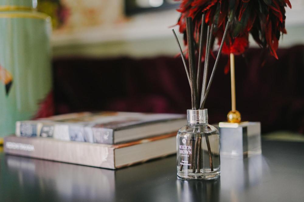 a vase with flowers in it next to two books at 40 Winks Hospitality in Durham