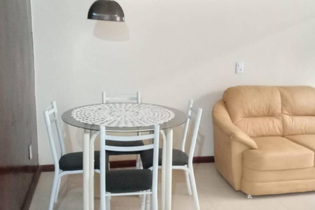 einen Tisch und Stühle in einem Zimmer mit Sofa in der Unterkunft Apto no Centro de Conservatória in Conservatória