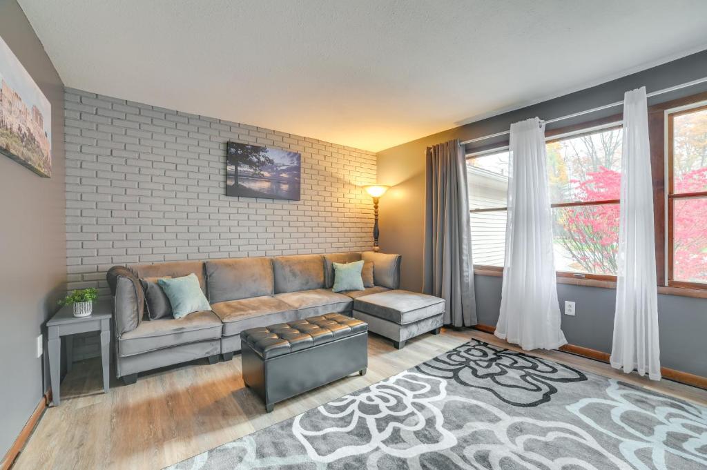 a living room with a couch and a brick wall at Houghton Lake Vacation Rental - Walk to the Water! in Houghton Lake