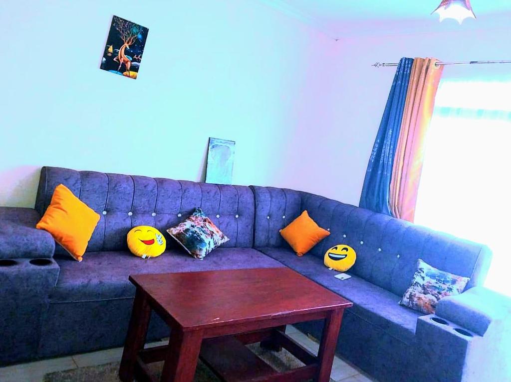 a blue couch with pillows and a table in a living room at Bree Airbnb in Malindi