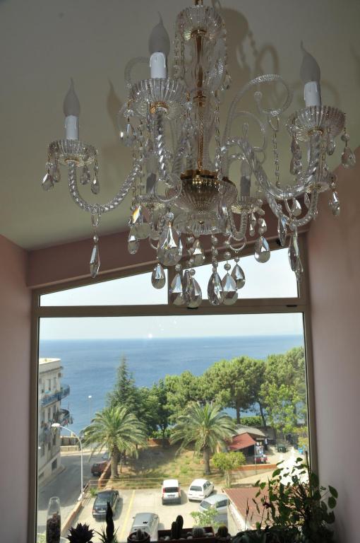 a chandelier hanging from a window with a view at Hotel Scilla in Scilla