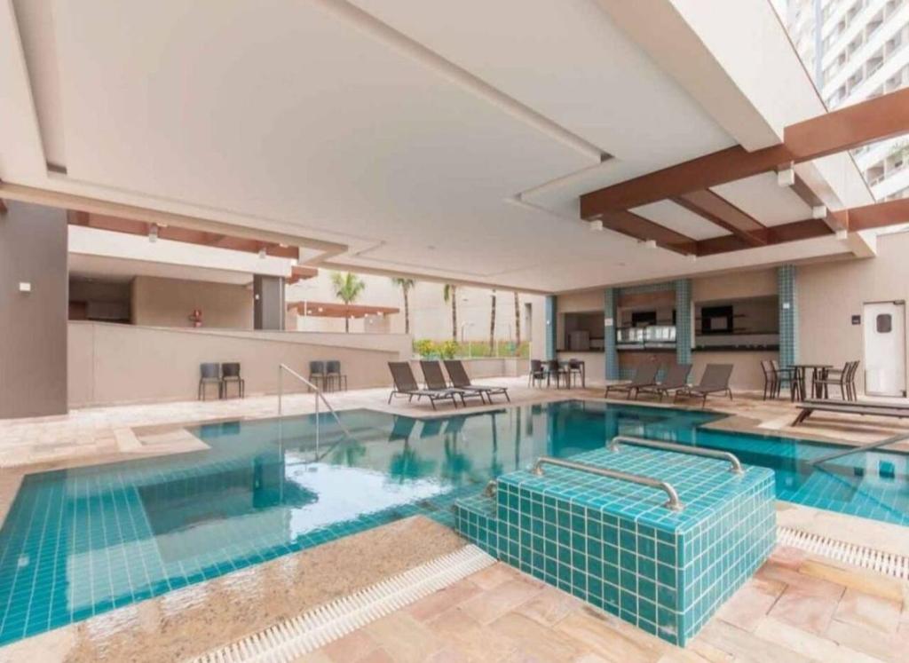 a large pool with blue water in a building at Enjoy Solar das Águas Olímpia in Olímpia