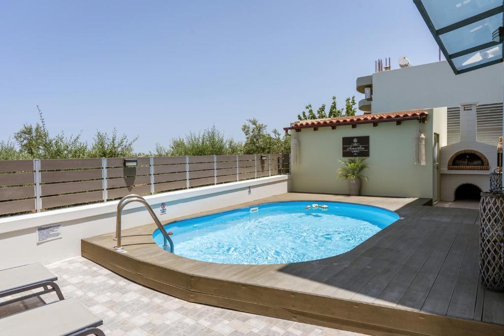 a hot tub on a patio with a fence at Amarlia Villa in Skaleta