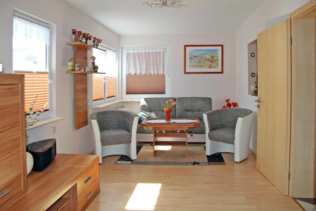 ein kleines Wohnzimmer mit einem Tisch und Stühlen in der Unterkunft Ferienbungalow Brigitte in Spandowerhagen
